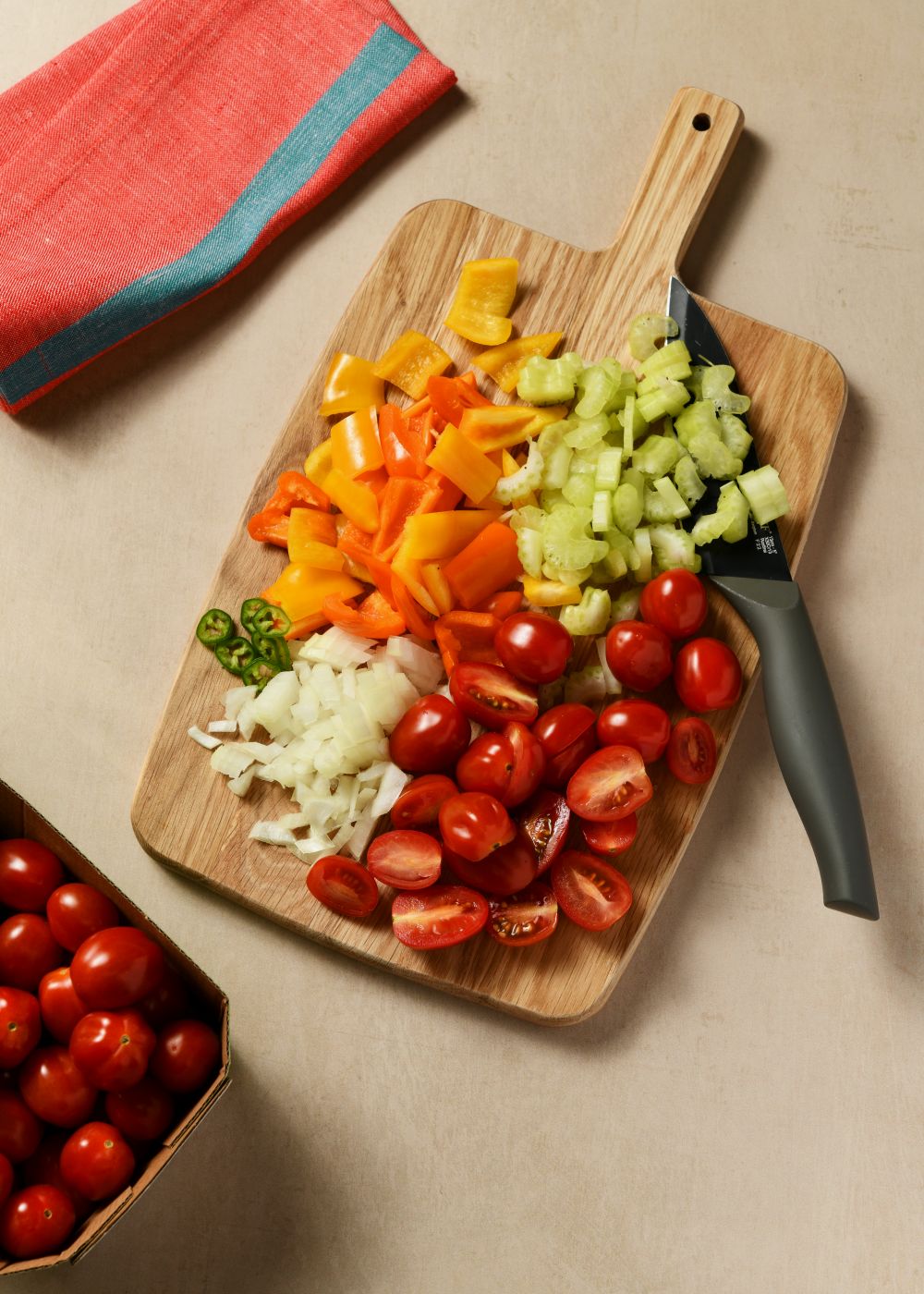 იმავე ტაფაზე მოშუშეთ დაჭრილი ხახვი, ნიორი, წიწაკები და ნიახურის ღერო. დაუმატეთ ტომატის პასტა. შემდეგ შუაზე გაჭრილი ჩერი პომიდვრები, შაქარი და შუშეთ მზადყოფნამდე. გასინჯეთ და შეუსწორეთ მარილი.