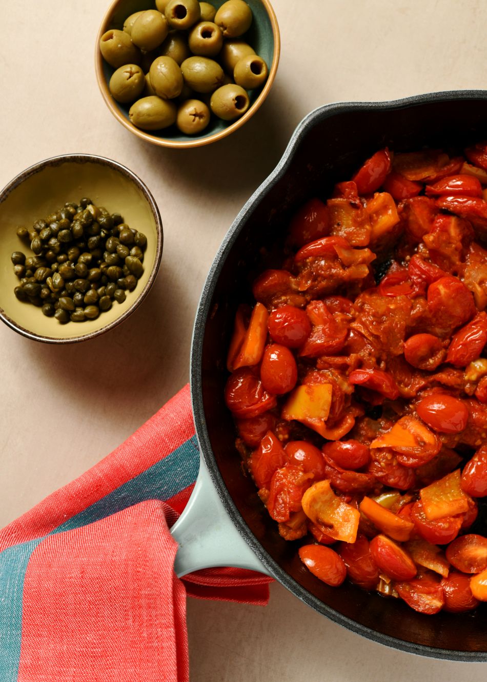 ტაფაშივე ჩაამატეთ ბადრიჯანი და წამოადუღეთ, სოუსის სისქე დაარეგულირეთ ანადუღარი წყლით საჭიროებისამებრ. პასტისთვის უფრო წვნიანი აჯობებს, სენდვიჩებისთვის - წვენის გარეშე. სულ ბოლოს დაუმატეთ შუაზე გაჭრილი ზეთისხილები, კაპარი და დაჭრილი ოხრახუში.